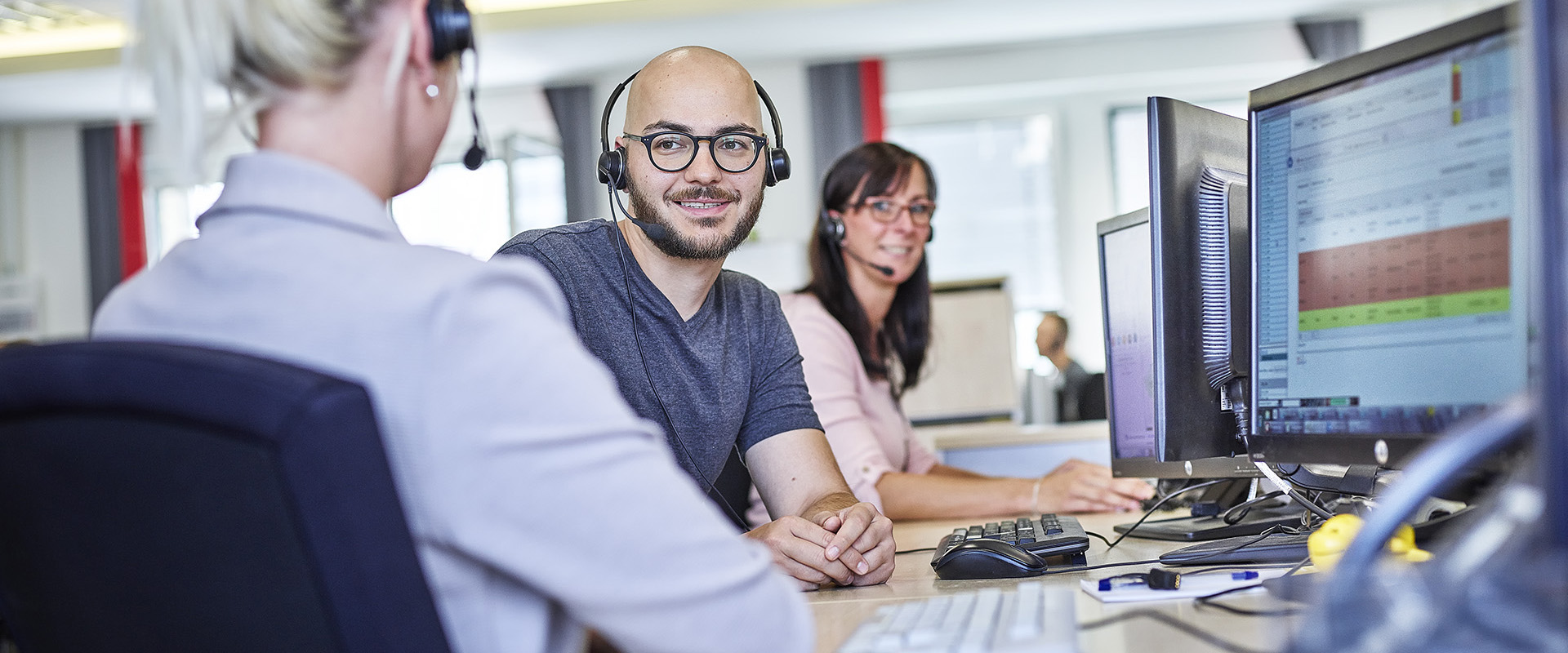 Mitarbeiter mit Headset am Arbeitsplatz